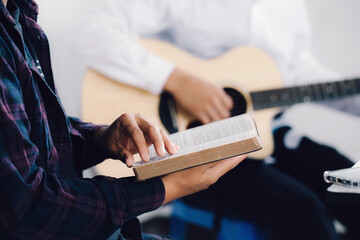 Wall Mural - Male adults are reading the Holy Scriptures pointing to the characters.And befriends playing guitar, The books of the Bible, Concepts of Christianity.