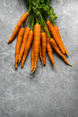 Wall Mural - Fresh organic bunch of carrots on a gray kitchen top aerial view