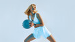 Fitness woman training with a medicine ball. Blonde Girl in fitness wear doing fitness training using a medicine ball. Creative studio shot with blue light