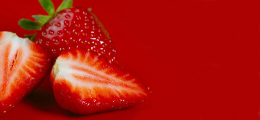 Wall Mural - Fruit background. Strawberries on a red background.Strawberries close-up. Side view, close-up, horizontal. Concept of summer and vegetarianism. Copy space to the right.