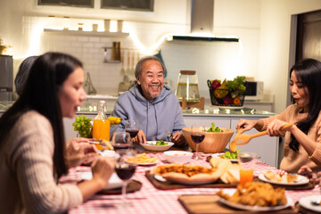 Asian big family enjoy eating food on dining table in Christmas party.