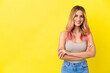 Young woman over isolated yellow background keeping the arms crossed in frontal position