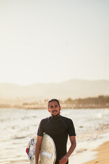 One skimboarder walking out of water in order to catch some waves at Can Pere Antoni beach (Palma de Mallorca, Spain)