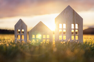 ecological wood model house in empty field at sunset