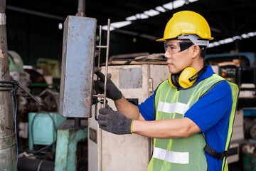 Asian engineer male worker maintaining machine lathe metal at the industry factory. Asian factory worker check or maintenance CNC machine in industry factory