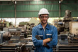 © amorn - Portrait of male factory worker working and standing in front of manufacturing machinery in the industry factory