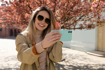 Canvas Print - Young woman taking selfie on city street