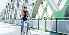 Young Business Man Commuter With Bicycle Going To Work Outdoors In City, Riding On Bridge.