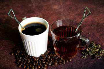 Hot coffee and tea, coffee beans and tea leaves on the table top.