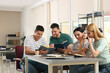 © New Africa - Young people discussing group project at table in library