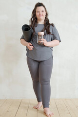 Wall Mural - Happy young disable female in activewear holding rolled mat and bottle of water