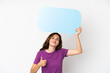 © luismolinero - Young caucasian woman isolated on white background holding an empty speech bubble with thumb up