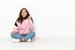 © luismolinero - Young caucasian woman sitting on the floor isolated on white background thinking an idea pointing the finger up