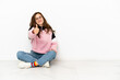 © luismolinero - Young caucasian woman sitting on the floor isolated on white background with thumbs up because something good has happened