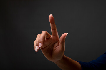 Close up of hands touching touching invisible screen against black background