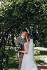 Walking the bride and groom outdoors. Beautiful summer photo session in nature.