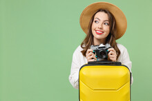Close Up Dreamful Tourist Woman Wearing Casual Clothes Hat Hold Vintage Camera Yellow Suitcase Valise Isolated On Green Background Passenger Travel Abroad Weekend Getaway Air Flight Journey Concept