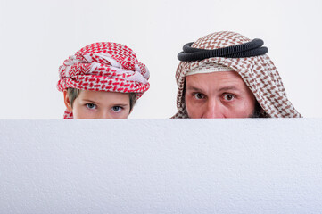 Arabic father with son Holding White Poster And Sticking Out Tongue stock photo