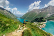 © Eva - Beautiful scenic view of high mountain lakes.Girl hiking to the Mooserboden dam in Austrian Alps.Active sporty lifestyle.Wonderful nature landscape,turquoise tranquil water,holiday travel scene