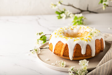 Homemade lemon cake decorated with white glaze and zest