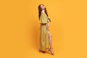 Wall Mural - Red-head woman in yellow dress posing in studio. Summer mood. Full lenght.