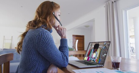 Poster - Caucasian woman wearing phone headset having a video call with female colleague on laptop at home