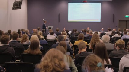 group of people listening lecture seminar of coach speaker with display screen stage. audience confe