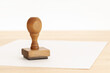 © Formatoriginal - Vintage Rubber stamp and blank paper on wooden table. Copy space