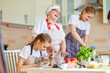 © Roman - Happy family cooking together on kitchen. Mother, grandma and daughter at home, chopping ingredients for salad or pizza. Home recreation and food preparation on weekend. focus on teen girl