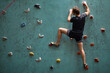 © Roman - Caucasian man climber. Extreme indoor climbing. Strong man practicing climbing on artificial rock wall in sports club. Strong sporty male and male training speed bouldering session.