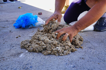 Sticker - Closeup of hands mashing soil on a concrete surface