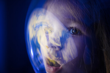 Wall Mural - girl dreams of becoming astronaut and flying into space. reflection of planet