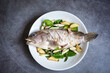 Fresh raw grouper fish on plate with herbs and spices for cooked food seafood steamed fish