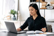 © Kateryna - Cute smart confident asian girl, freelancer or student sitting at work desk, using laptop for work or study, taking notes during online webinar or distance learning, looking at screen, smiling