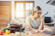 © vacancylizm - happy young woman smiling in a modern kitchen. beautiful Asian woman stands in a kitchen cooking wearing a red apron. The healthy menu she will cook is salmon, steak and salad.