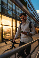 Wall Mural - Man using a cellphone while walking with his bicycle in the city