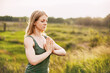 A young girl meditates after a yoga class in nature. The concept of mental health and healthy lifestyle