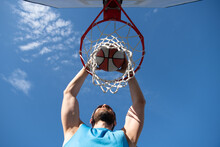 Close Up Image Of Professional Basketball Player Making Slam Dunk During Basketball Game In Outdoor Basketball Court.