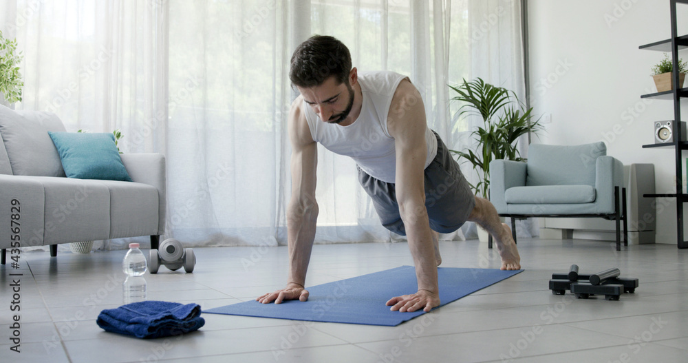 Athletic man doing push ups at home - obrazy, fototapety, plakaty 