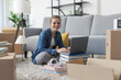 © StockPhotoPro - Cheerful woman connecting online in her new home