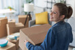© StockPhotoPro - Happy woman carrying boxes in her new home