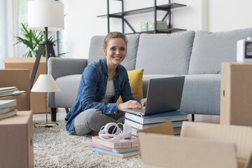 Wall Mural - Cheerful woman connecting online in her new home