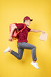 © Timeimage - Asian delivery man wearing a red uniform posing on yellow background
