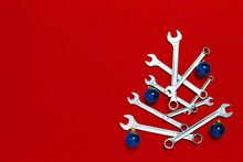 Christmas Tree Made Of Wrenches Decorated With Blue Balls On Red Background. New Year Banner With Tools. Postcard With Place For Greeting Text. Happy New Year. Industrial Holiday Concept. Copy Space