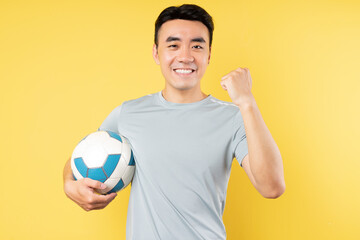 Asian man holding ball with victory expression