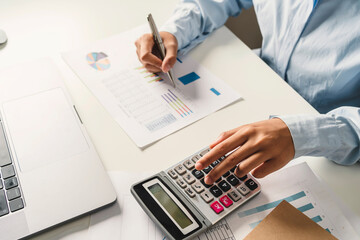 Fototapete - Woman accountant use calculator and computer with holding pen on desk in office. finance and accounting concept