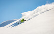 Skier rides in the mountain against the blue sky on fresh snow