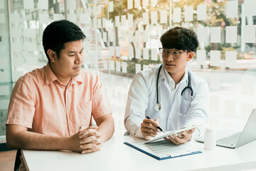 Wall Mural - Male patient listening to doctor at desk and consulting with healthcare in hospital.