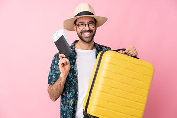 Young caucasian man over isolated background in vacation with suitcase and passport