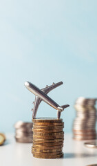 The airplane stands on a stack of coins. A toy little airplane is lying sideways on the coins